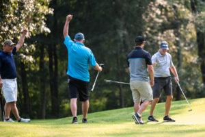 man holding victorious fist in the air at golf outing